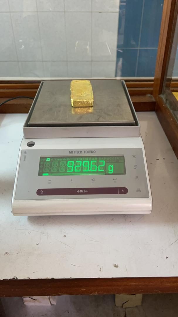 A refined gold bar being weighed on a precision Mettler Toledo scale