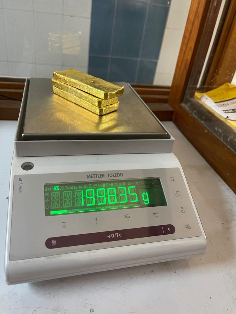 Two stacked gold bars on a Mettler Toledo precision scale displaying a weight of 1998.35 grams